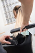 © Alvaro Lavin/Stocksy - woman hairdresser ironing and styling client's hair
