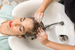 © Alvaro Lavin/Stocksy - woman hairdresser washing long hair with soap in hairdresser's shop