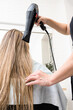 © Alvaro Lavin/Stocksy - woman hairdresser drying long wet hair in hairdresser's salon