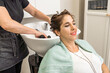© Alvaro Lavin/Stocksy - woman hairdresser washing long hair with soap in hairdresser's shop