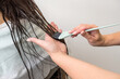 © Alvaro Lavin/Stocksy - woman hairdresser giving hair treatment to woman with long brown hair