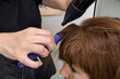 © Alvaro Lavin/Stocksy - woman hairdresser drying long wet hair in hairdresser's salon