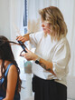 © Iryna Shepetko/Stocksy - Stylist twists hair on a curling iron