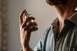 © Lucas Ottone/Stocksy - Man applying perfume to his neck