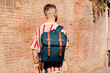 © Lucas Ottone/Stocksy - Urban man walking with a backpack