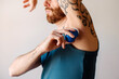 © Lucas Ottone/Stocksy - Man applying deodorant on his armpit