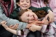 © Evgenij Yulkin/Stocksy - Laughing child in family hugs