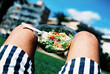 © Juan Moyano/Stocksy - man on the grass about to eat a packaged salad