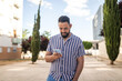 © Lupe Rodríguez/Stocksy - young bearded man using mobile phone outdoors