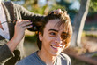 © ByLorena/Stocksy - Mom cutting her teenage son's hair outside