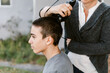 © ByLorena/Stocksy - Teenager shaving hair outdoors