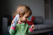 © Maria Manco/Stocksy - Toddler tries to take her own temperature
