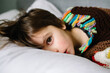 © Maria Manco/Stocksy - Ovehrhead view of boy on couch at home while sick with cold and flu