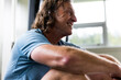 © Rob and Julia Campbell/Stocksy - Sweaty, tired, happy older man sitting on floor during workout.