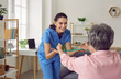 © Studio Romantic - Friendly, smiling nurse or physiotherapist helping a retired old woman to do fitness exercises with an elastic rubber band. Senior care and physiotherapy concepts