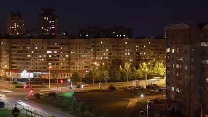 Wall Mural - Time-lapse Night Scenic View Of High-rise Houses. City Traffic And High-rise Houses. Elevated View Cityscape Skyline. Night Light Lighting Time Lapse. Street Background Backdrop Night Time Lapse.