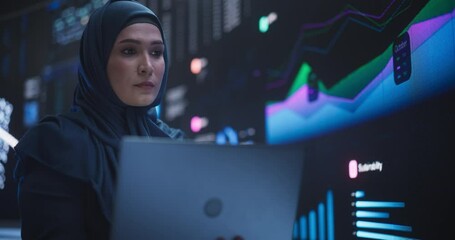 Leinwandbilder - Portrait of Arab Female Working in an Advanced Technology Company. Woman Wearing a Hijab, Using Laptop Computer in a Room with an Artificial Intelligence Neural Network Software on a Digital Screen