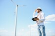 © Serhii - Portrait of focused indian man standing on field with wind turbines