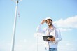 © Serhii - Indian Engineer in wheat field checking on turbine production