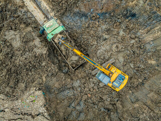 Wall Mural - Aerial view of excavator equipment at the construction site. The excavator digs earthwork at the construction site.