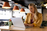 Fototapeta  - Happy plus size caucasian casual businesswoman using laptop at desk