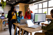 © WavebreakMediaMicro - Diverse male and female colleagues in discussion using laptop at desk in office