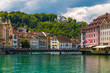 Great view of Lucerne's turquoise river Reuss with the historic riverfront buildings, the bridge Reussbrücke and the hotel Château Gütsch on the Gütsch hill in the back.