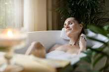 Woman Enjoying Spa Bath With Foam And Wooden Massage Brush. Body Care