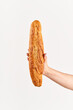 Baguette bread in woman hand over white background
