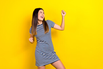 Wall Mural - Photo of charming crazy happy asian girl raise fists rejoicing excited winning wear trendy short sarafan isolated yellow background