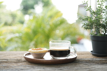 Wall Mural - Coffee in a glass cup and egg tart and flower outdoor relaxing