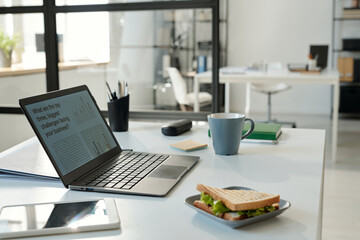 Aufkleber - Workplace of analyst or broker with laptop, tasty vegetarian sandwich on plate, cup of coffee, tablet and other supplies necessary for work