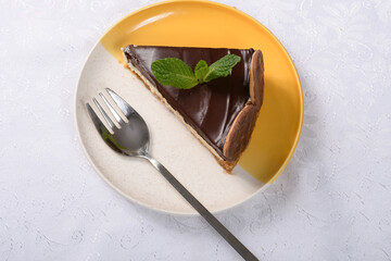 Wall Mural - slice of Dutch pie on a white and yellow plate on a table and yellow with a white tablecloth photographed close up