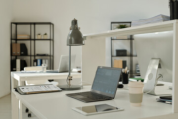 Aufkleber - Financial graphic data on screen of laptop standing on desk among paper documents, lamp, tablet and cup of coffee in spacious office