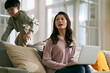© imtmphoto - working asian mother trying to work at home annoyed by hyperactive child