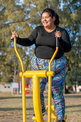 Wall Mural - Young fat woman doing aerobic exercise works upper and lower body in the park by the lake. Healthy lifestyle