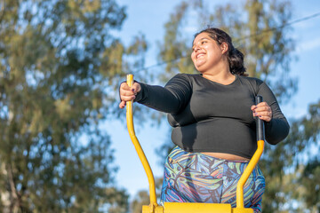 Wall Mural - Young fat woman doing aerobic exercise works upper and lower body in the park by the lake. Healthy lifestyle