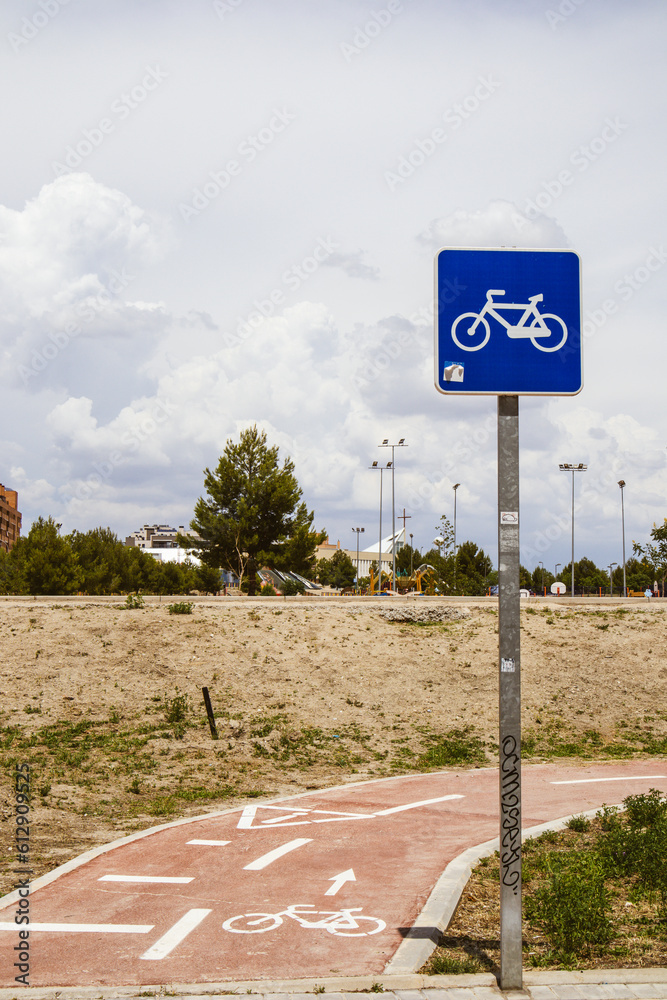 Bicycle path with a blue sign showing a bicycle in an urban environment ...
