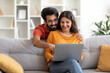 © Prostock-studio - Happy Young Indian Spouses Shopping Online With Laptop At Home