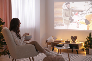 Sticker - Woman with popcorn watching romantic Christmas movie via video projector at home