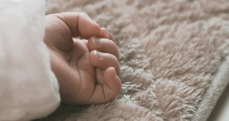 Sticker - A 2x slow motion of sleeping asian baby left hand on the carpet handheld