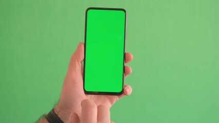 4K Young man hand touch smartphone with green screen on green background