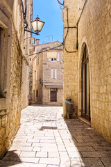 Wall Mural - Narrow street with stone houses. Old houses and old narrow alley in Trogir, Croatia, Europe. Streets in old town.