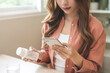 © KMPZZZ - Health care asian young woman using smart phone for reading, searching prescription on bottle medicine, pill label text about information online, instructions side effects, pharmacy medicament concept