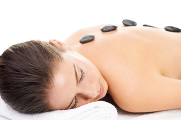 Sticker - Woman, massage and spa treatment with hot stone, relax and dermatology at wellness center. Female person, physical therapy and resting on bed with cosmetics isolated on transparent, png background