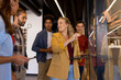 © WavebreakMediaMicro - Happy diverse creative colleagues in discussion brainstorming making notes on glass wall in office