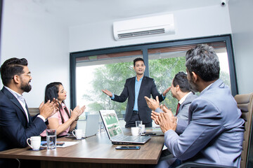 Wall Mural - Indian businesspeople clapping and appreciating businessman at conference. Company is greeting partner for sucess in business work.