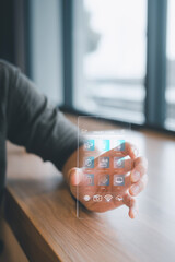 Young man uses transparent, futuristic smartphone to activate light using smart home software.