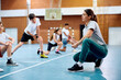 © Drazen - Female coach having class with elementary students at school gymnasium.