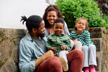 Wall Mural - Happy black kid and his family enjoys in their time together outdoors.